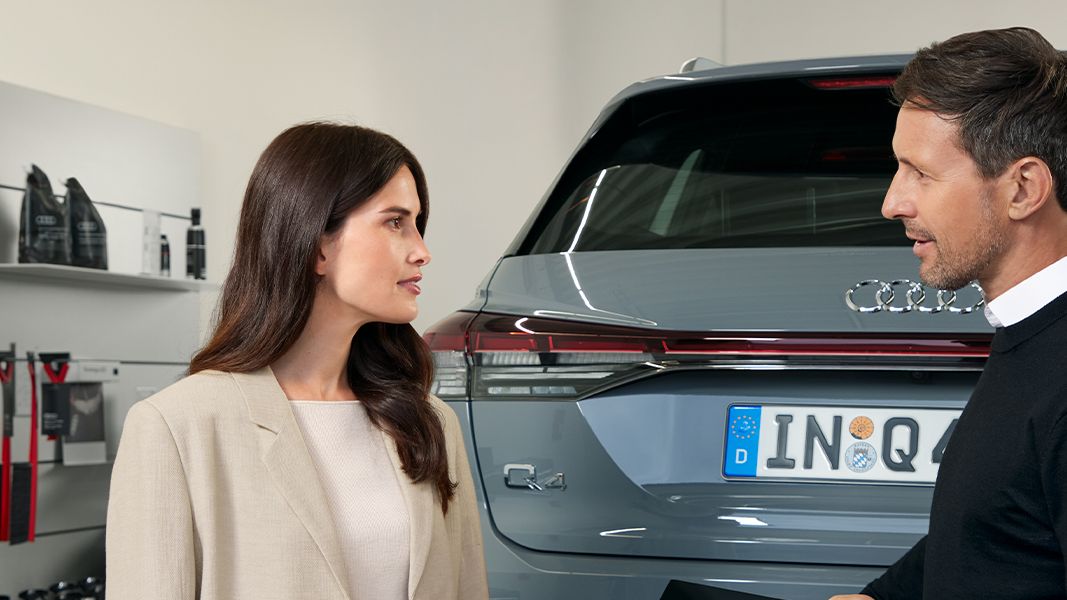 Duas pessoas à frente de um Audi Q4