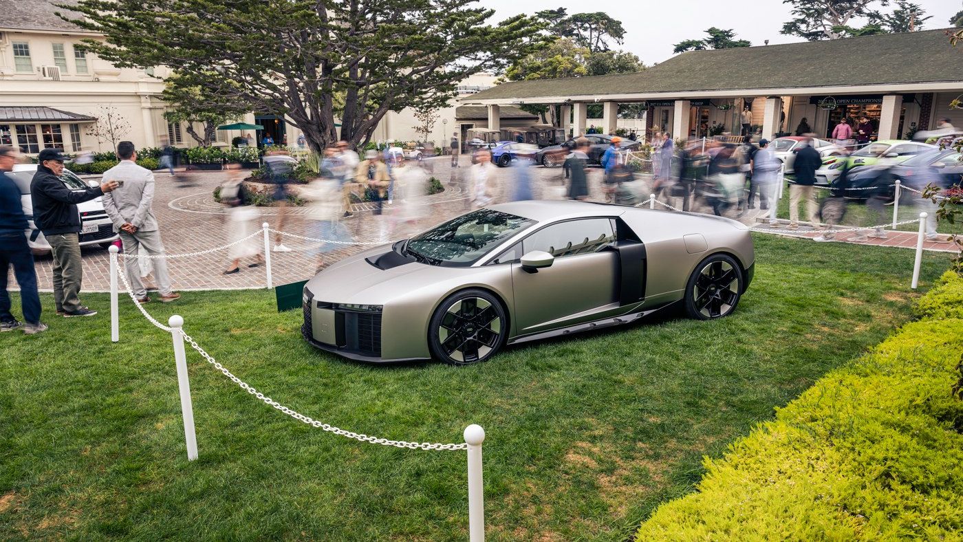 Audi Nuvolari em exibição sobre relva, cercado por pequenas correntes brancas. 