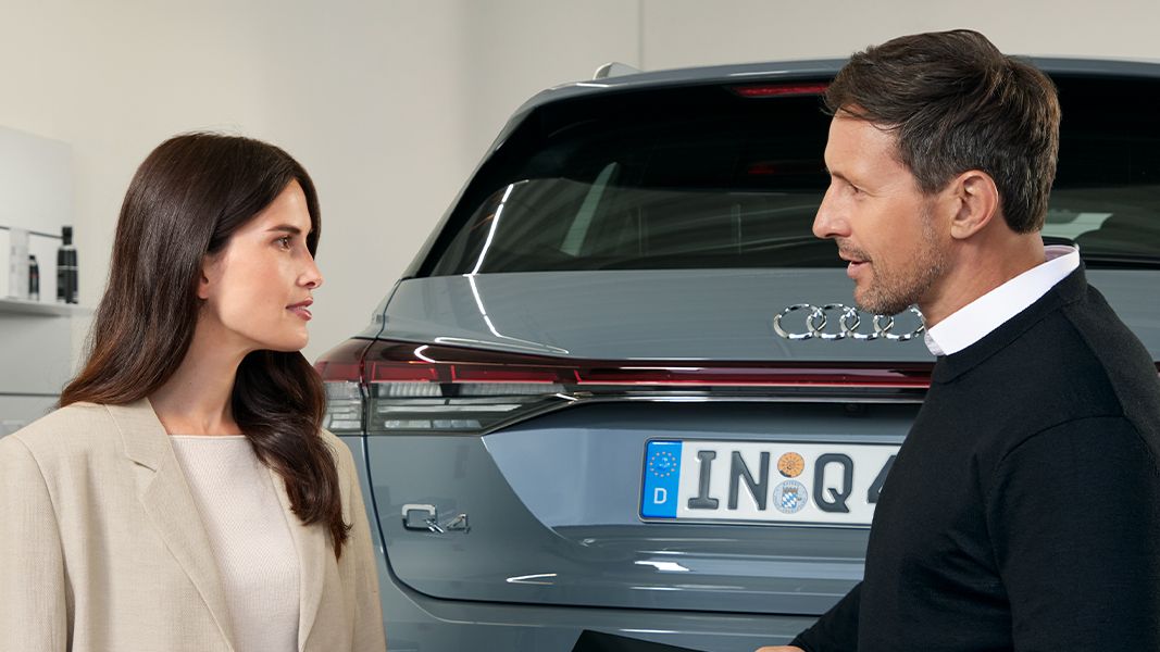 Duas pessoas à frente de um Audi Q4
