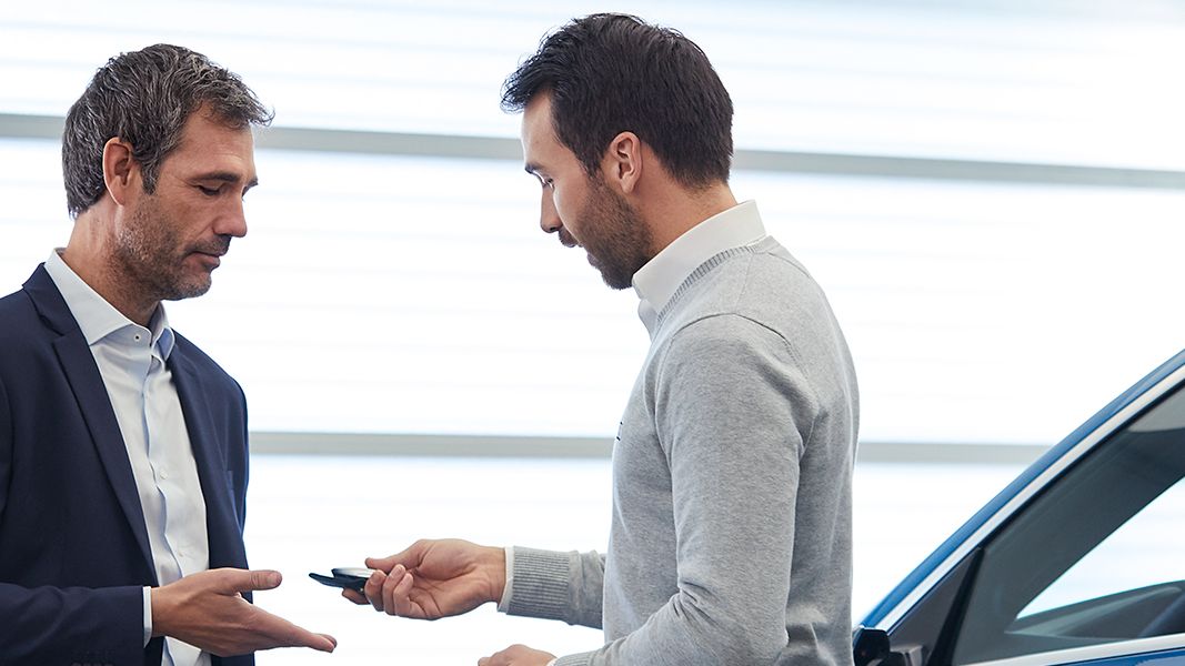 Dois senhores à frente de um automóvel Audi