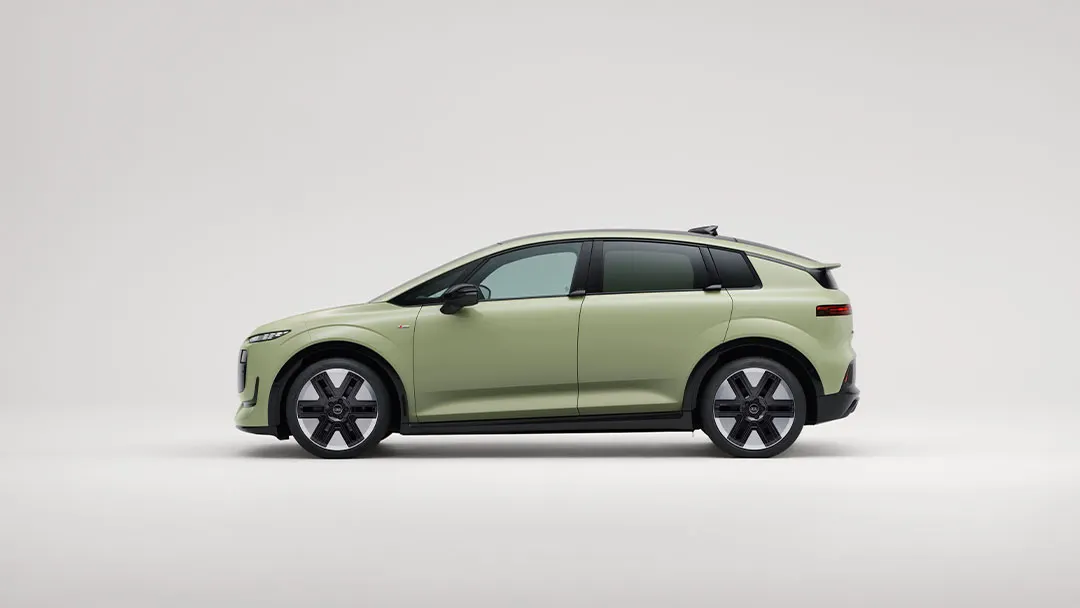 Audi A2 elétrico compacto, visto de lado, num fundo branco. O veículo é de cor verde-clara fosca, com linhas suaves.  