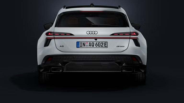 Der Audi A6 allroad e-hybrid frontal von hinten auf dunklem Hintergrund.