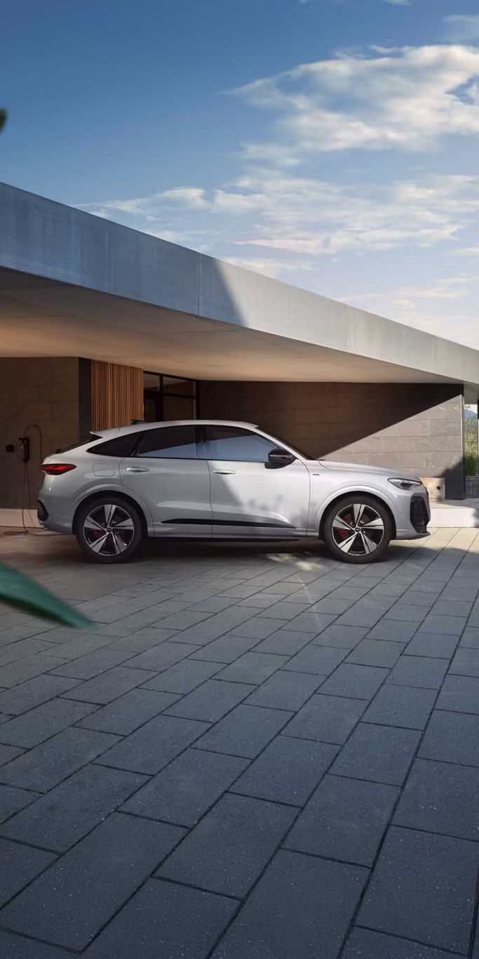 Audi Q5 Sportback e-hybrid Seitenansicht vor einem Haus