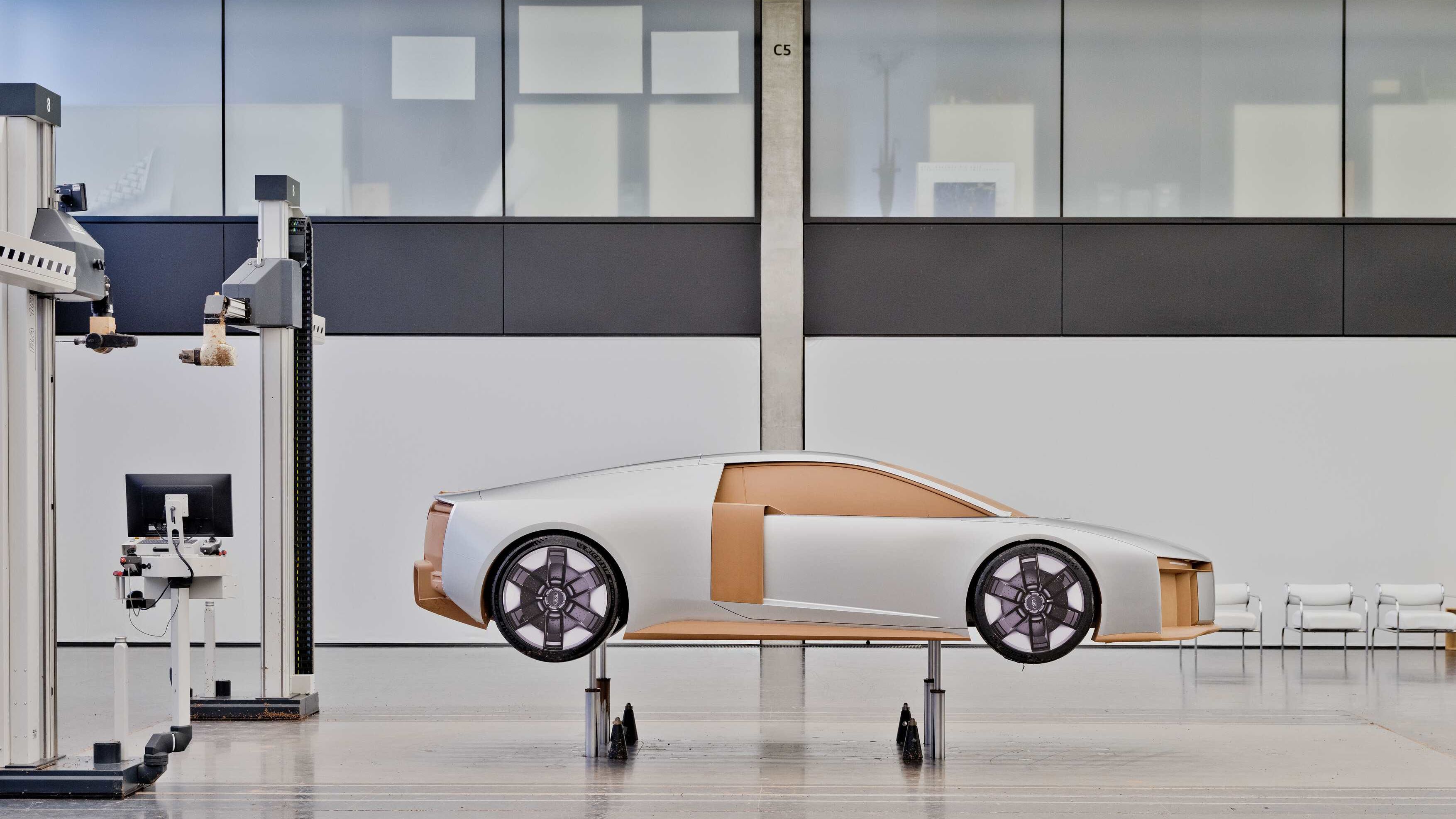 Modelo em escala de um audi Nuvolari, sem janelas nem detalhes internos, montado sobre suportes num estúdio de design limpo e minimalista. 