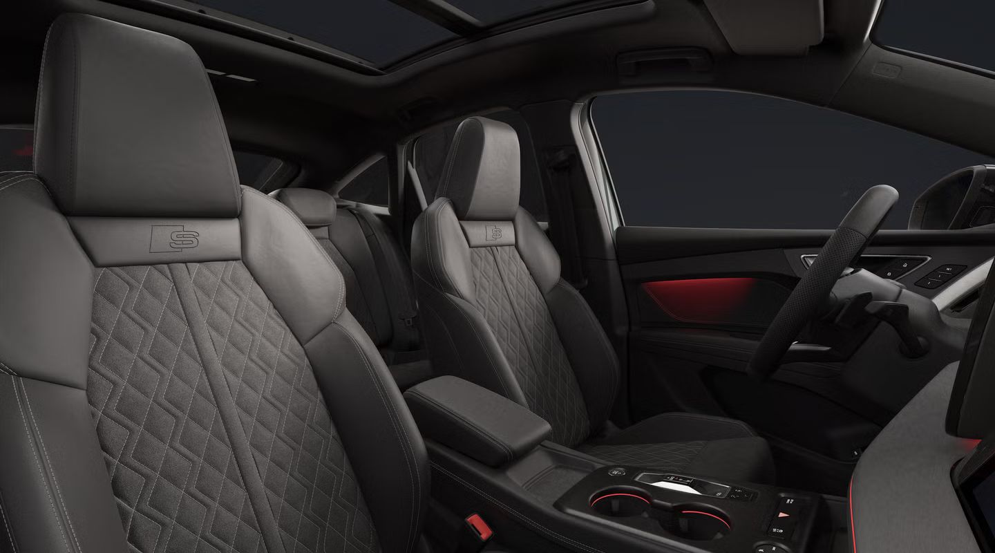 Blick auf den Innenraum des Q4 Sportback e-tron mit Cockpit, Vordersitzen und Rückbank.